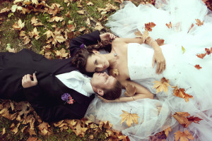 bride and groom in autumn leaves