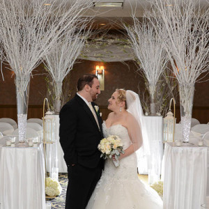 bride and groom in ballroom with white branches