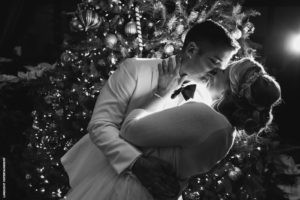 weddin kiss in front of christmas tree